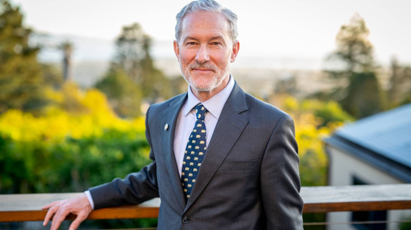 Rich Lyons, a white man with white hair and a white beard, smiling in a suit with a Berkeley bears tie, on campus