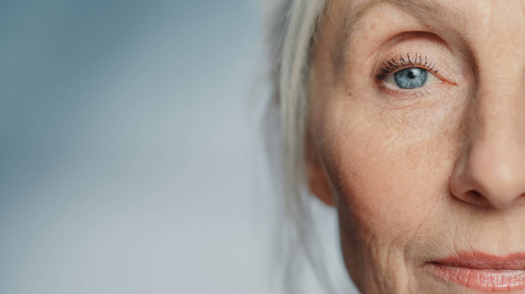 Senior woman with gray hair and blue eyes looking ahead straight at the camera