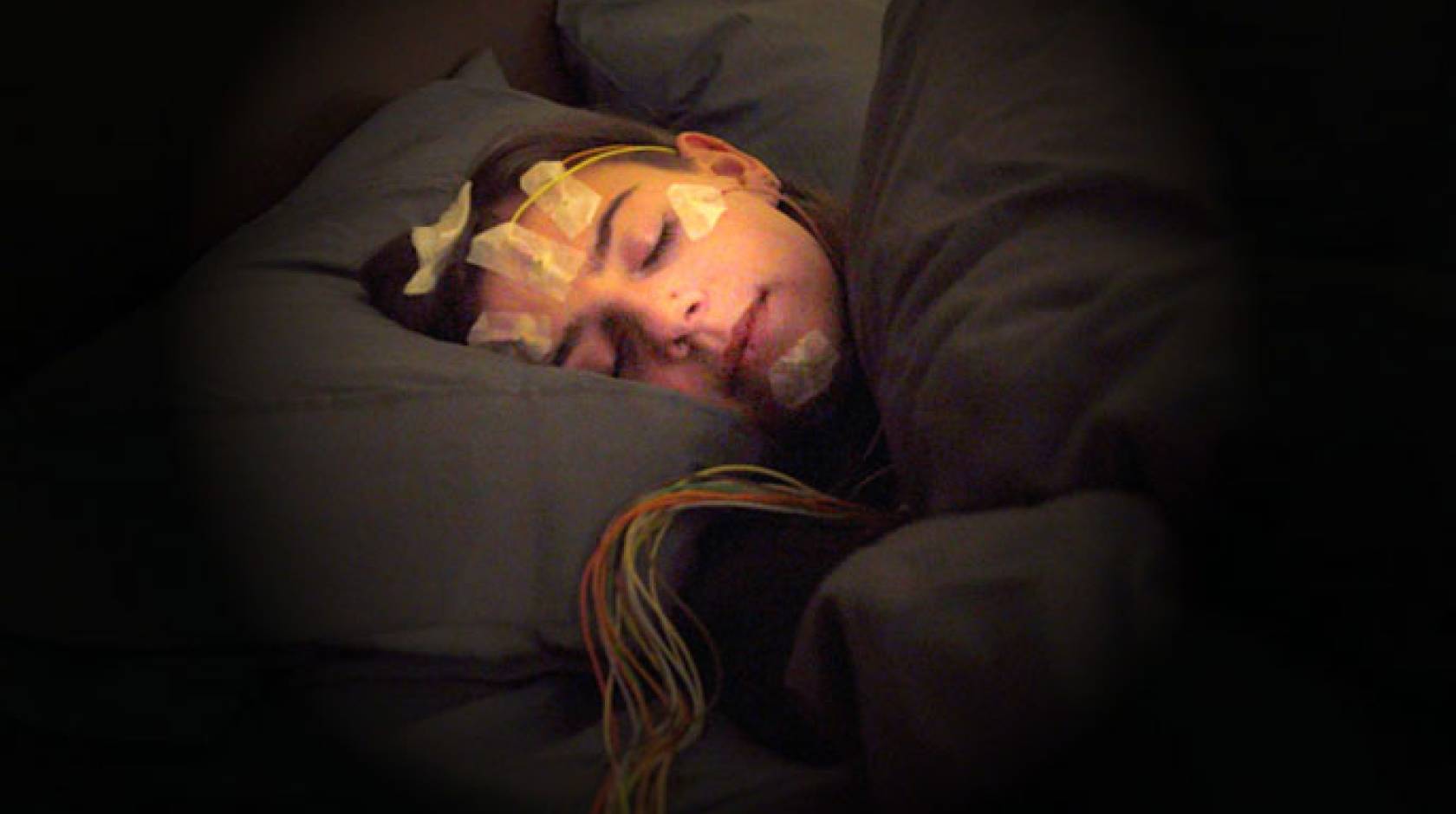 Woman sleeping with sensors on her head