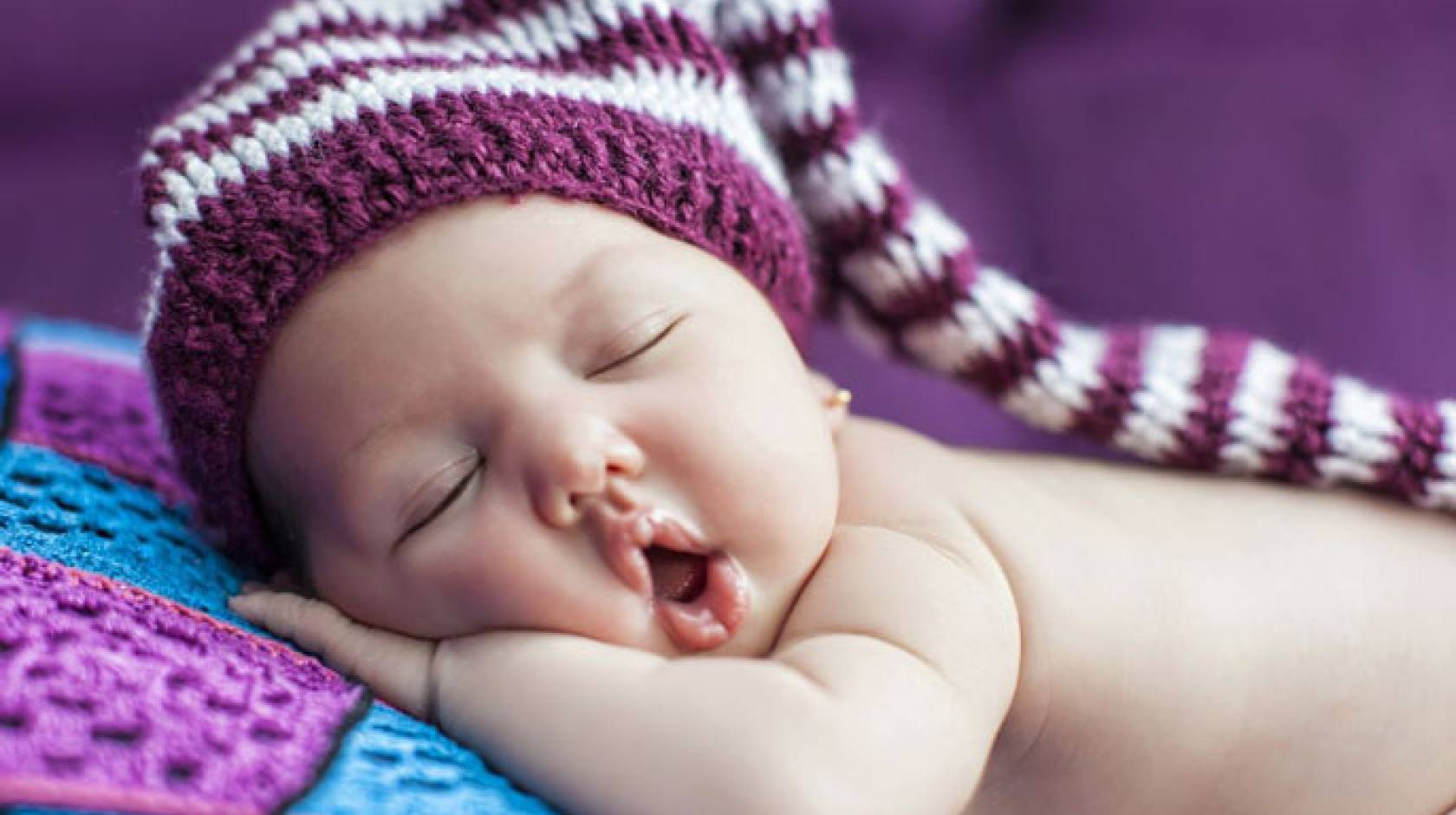 Baby sleeping in purple hat
