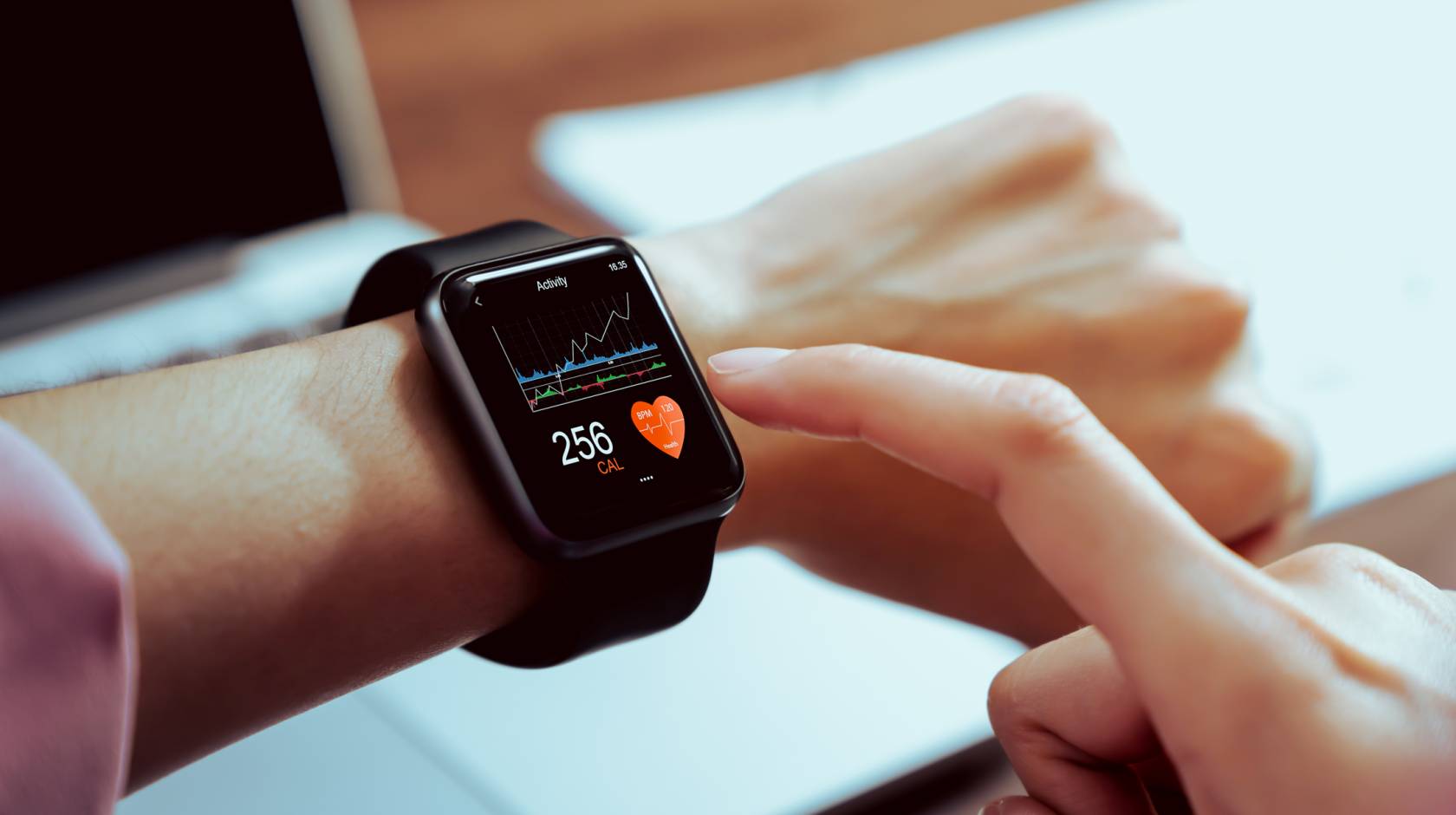 A person taps their smartwatch with the pointer finger of their other hand