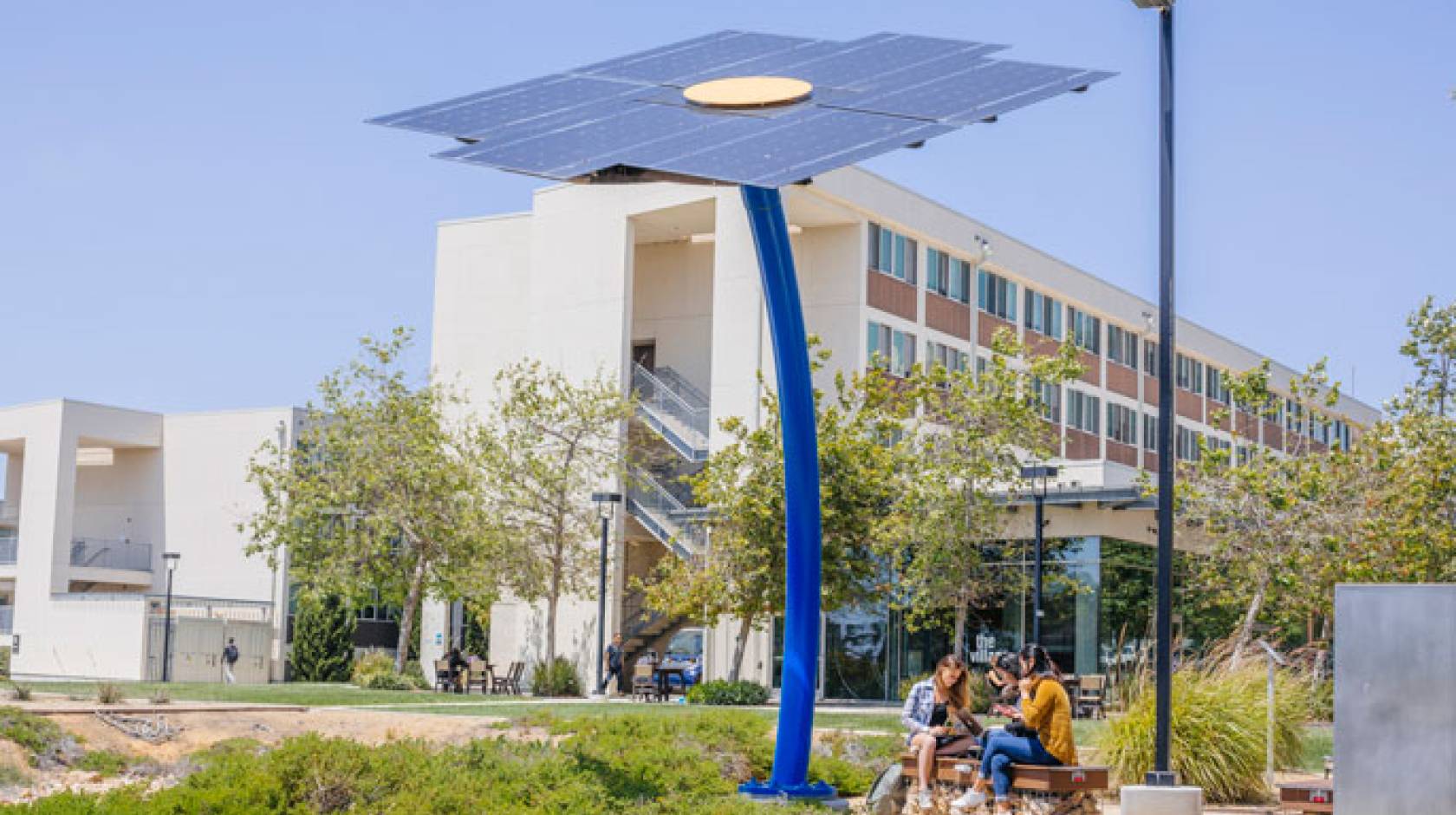 Outdoor solar panel charging station with students beneath