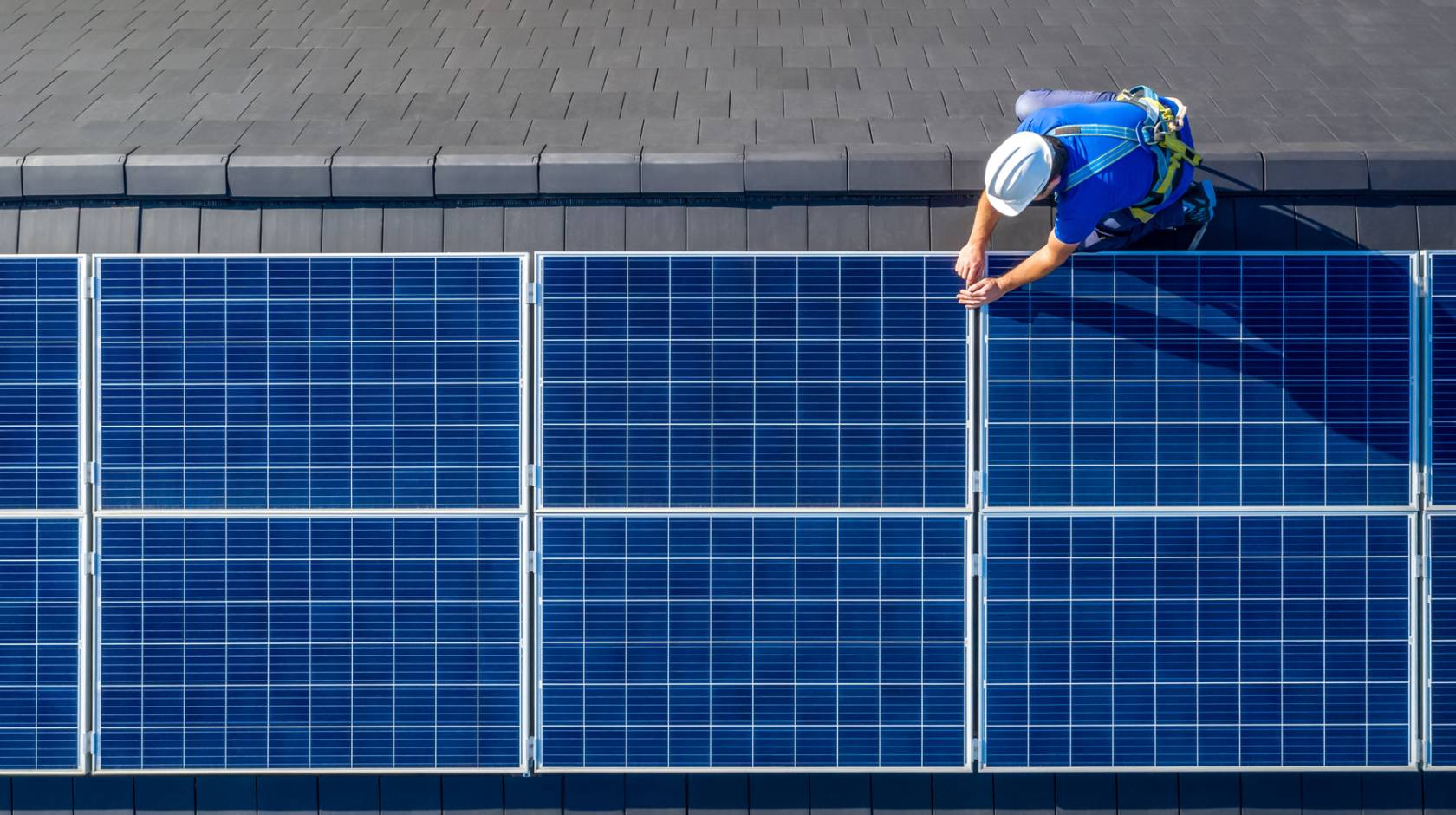 Man photographed from above working on a solar panel