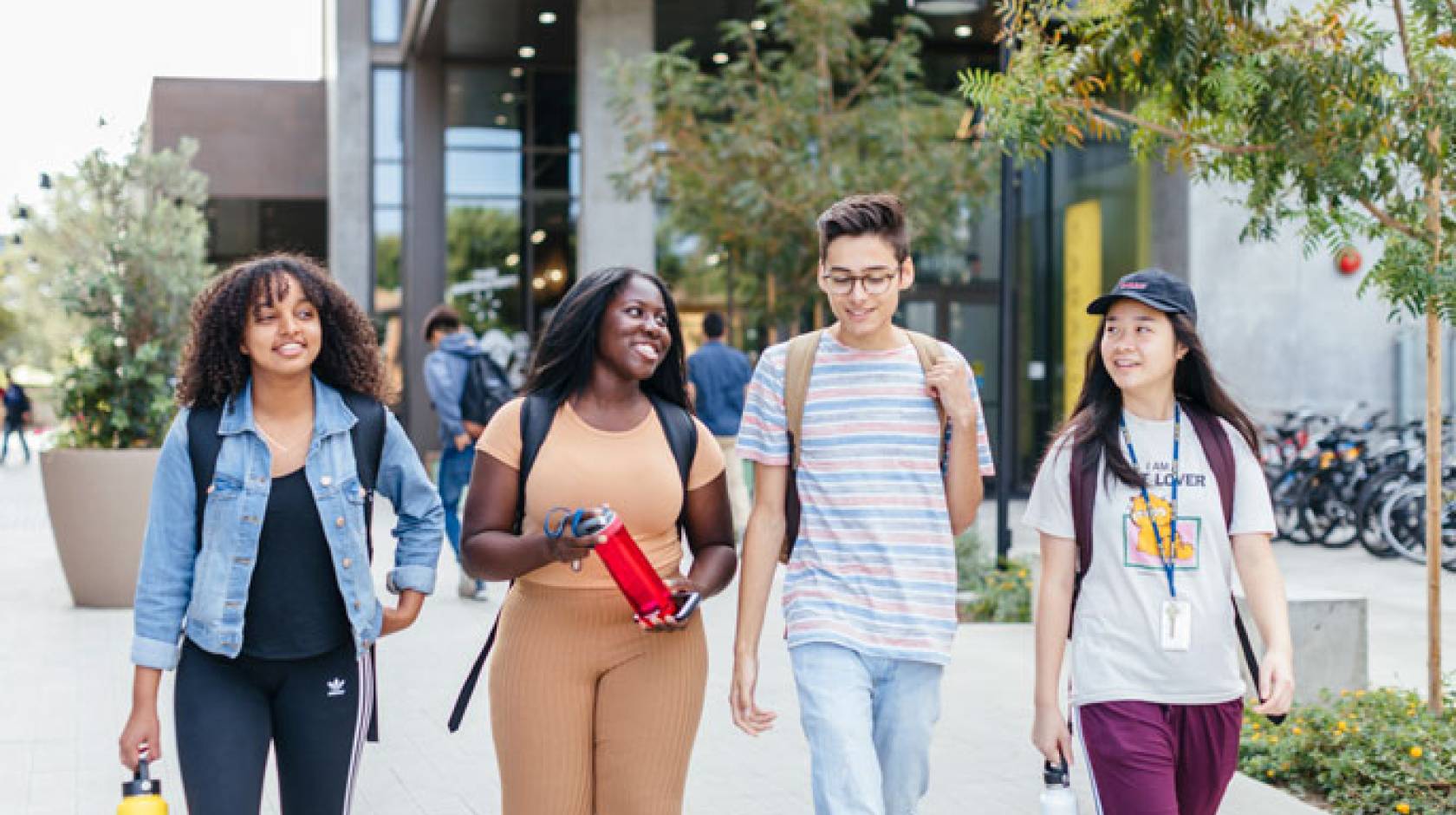 Four students walk UC Irvine's campus