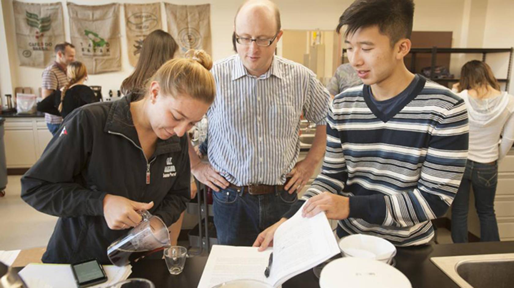 Associate professor William Ristenpart talks with Sabrina Perell, community regional development major, and Kyle Phan, an undeclared major, about the taste of their brew during a UC Davis “Design of Coffee” class in 2015. UC Davis is now establishing a Co