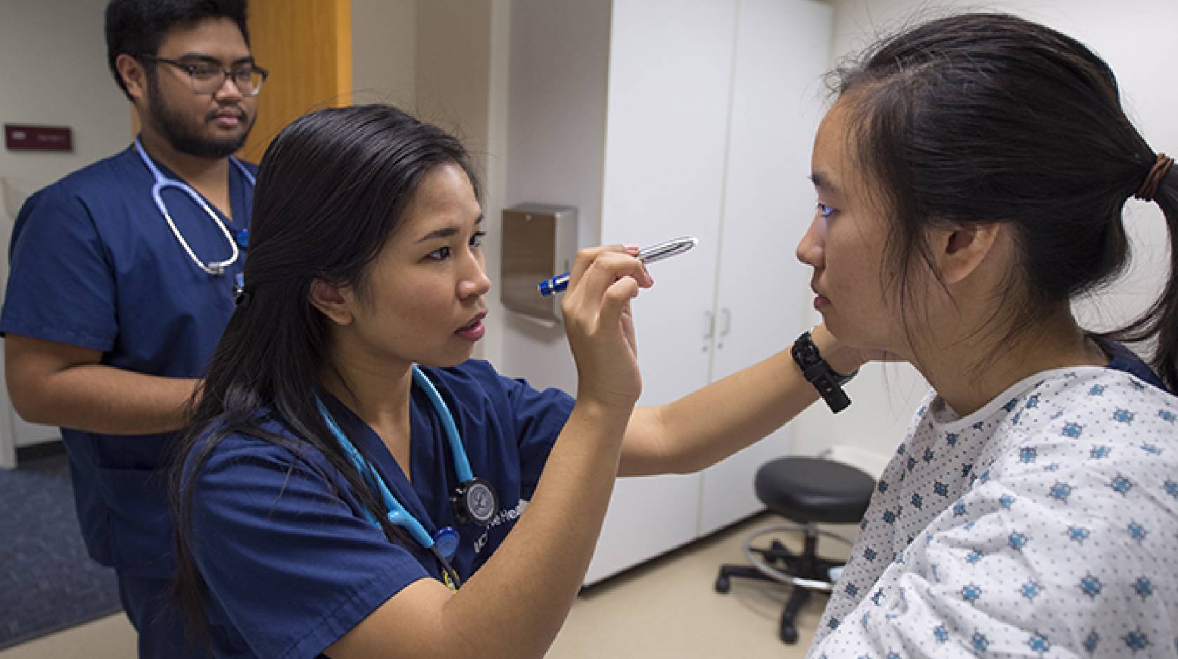 Bernadette Abadilla checks out fellow UCI nursing student Samantha Lee as Jon Frigillana, also a nursing student, watches. The top-ranked program has been elevated to a full-fledged nursing school by the UC regents.