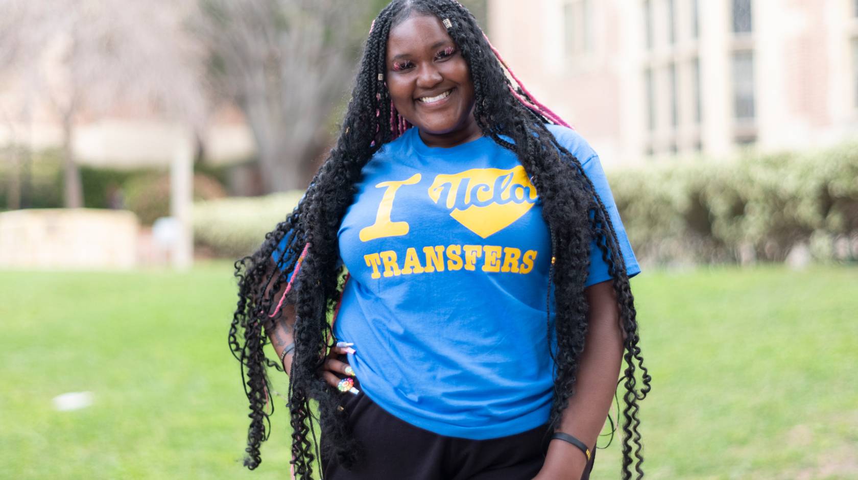 Black woman smiling with a T-shirt that says I UCLA-heart Transfers