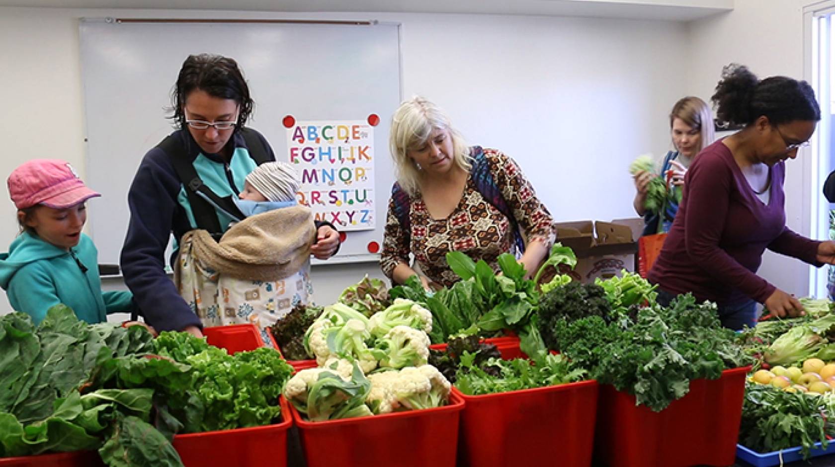 Rebecca Bork (middle) and her children, Ava and Finn, are among those who benefit from having fresh produce delivered by UCLA students to the UCLA University Village.