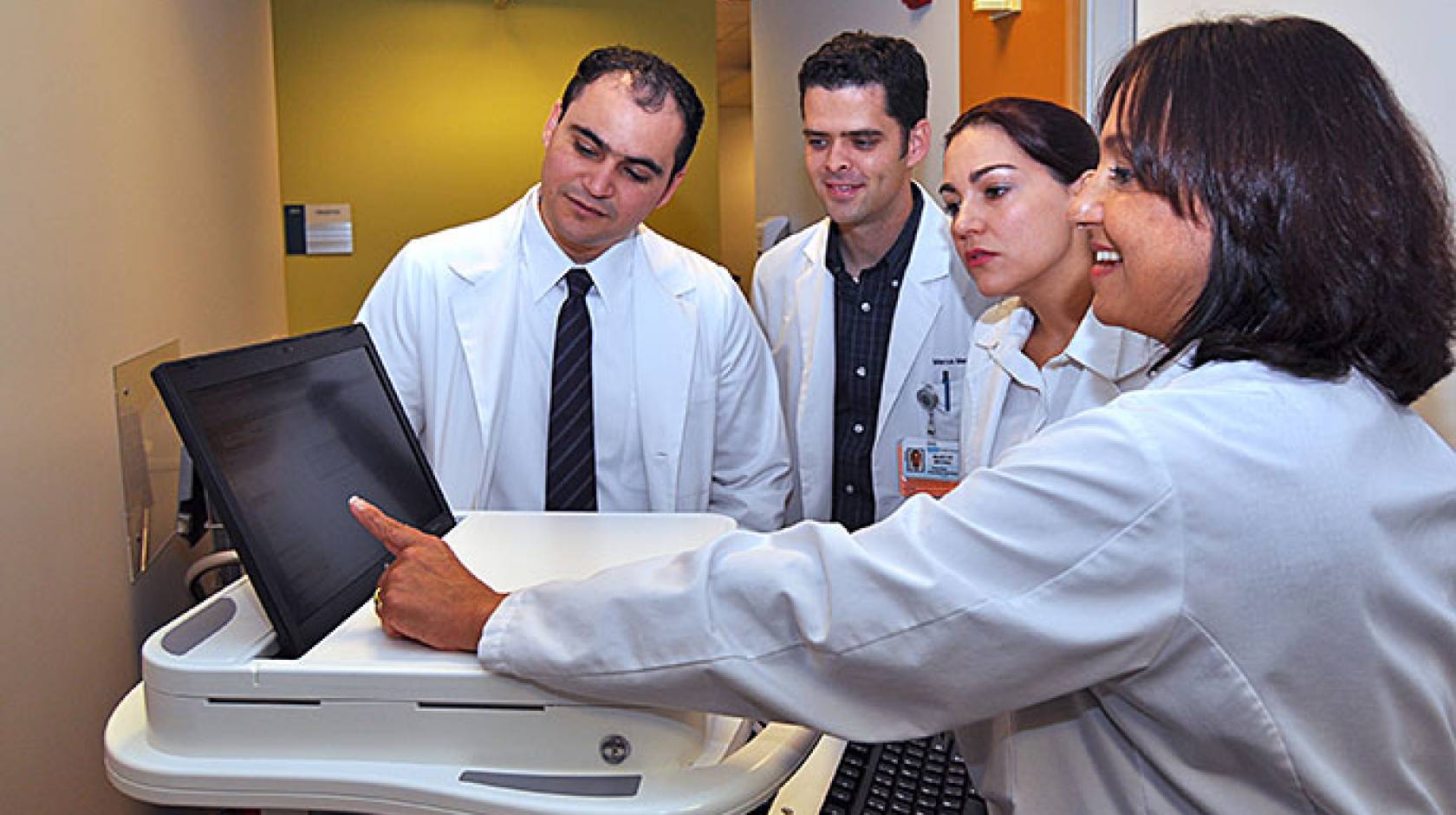 UCLA Dr. Michelle Bholat (right) gives a lesson on electronic medical records to international medical graduates (from left) Hendry Perez Pascual, Marcus Medina and Gloria Monsalve