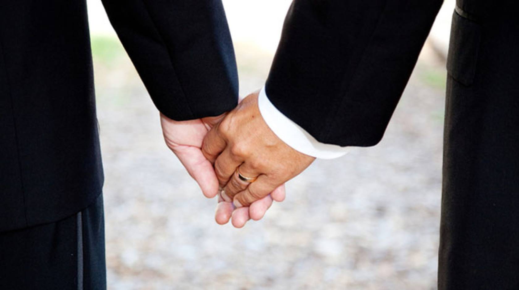 newlywed men hold hands