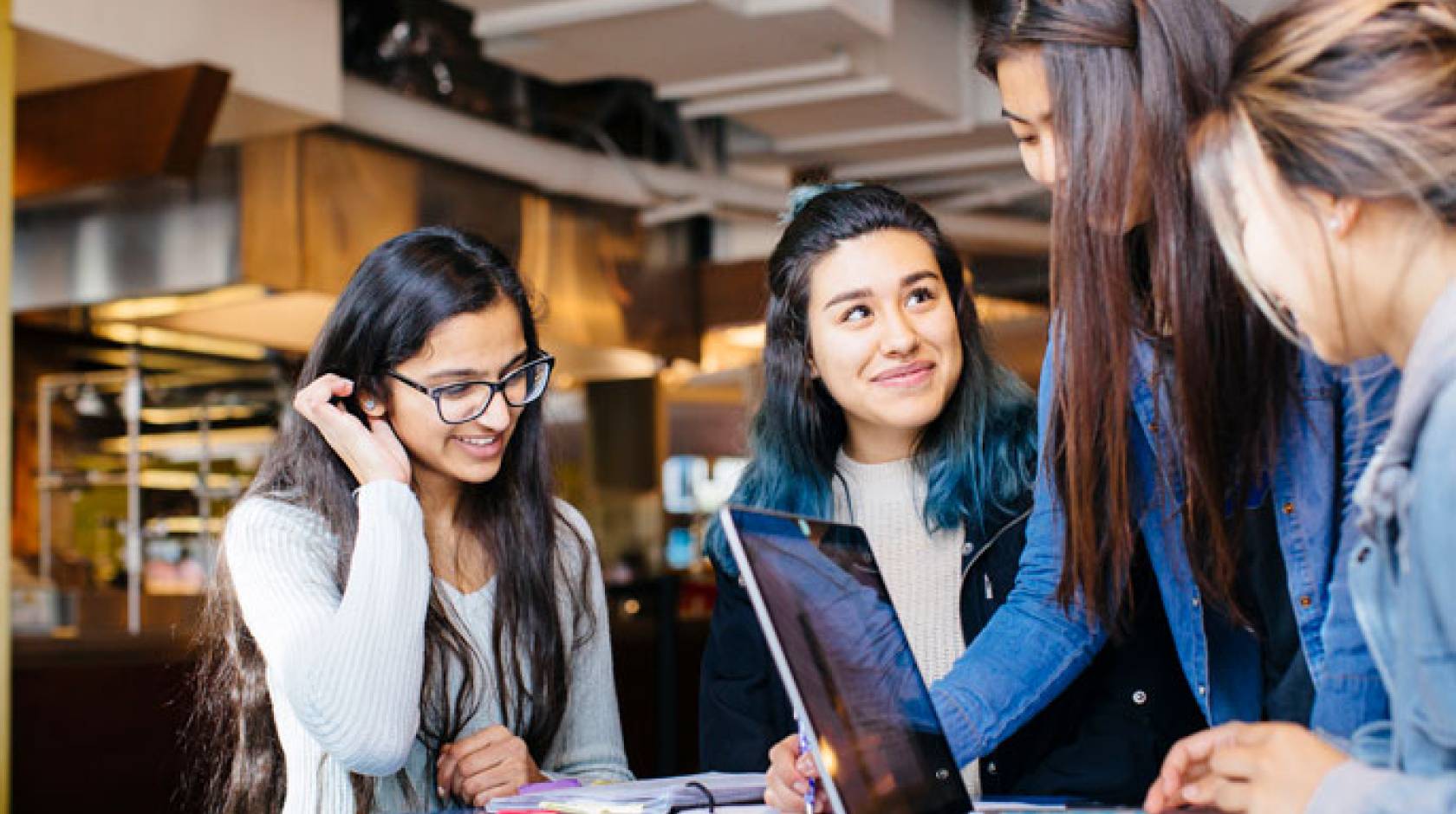 Four female students study together at a table