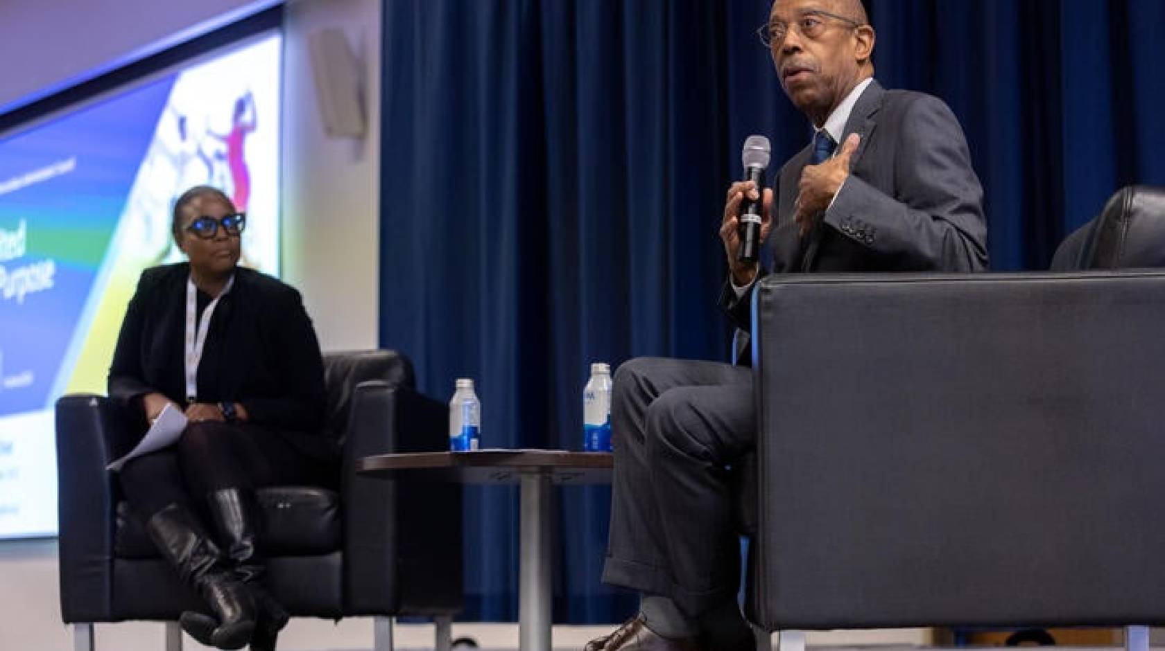 President Drake on stage with a Black woman educator as part of a panel