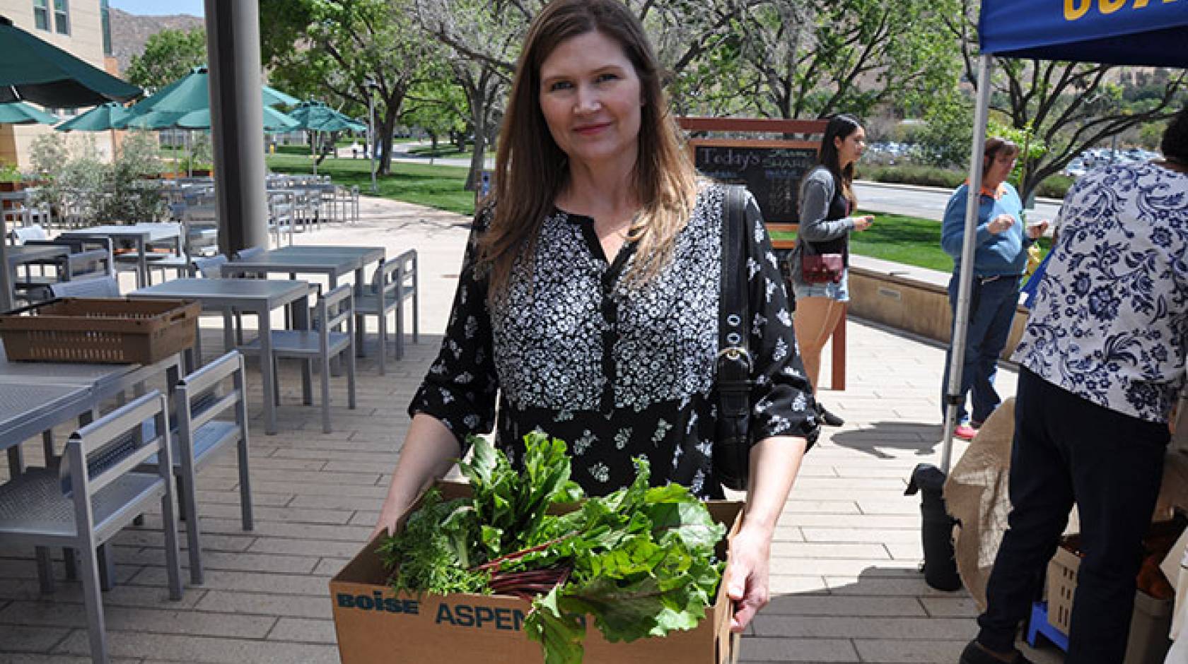 Dana Taylor picks up her produce at inaugural FarmShare event.