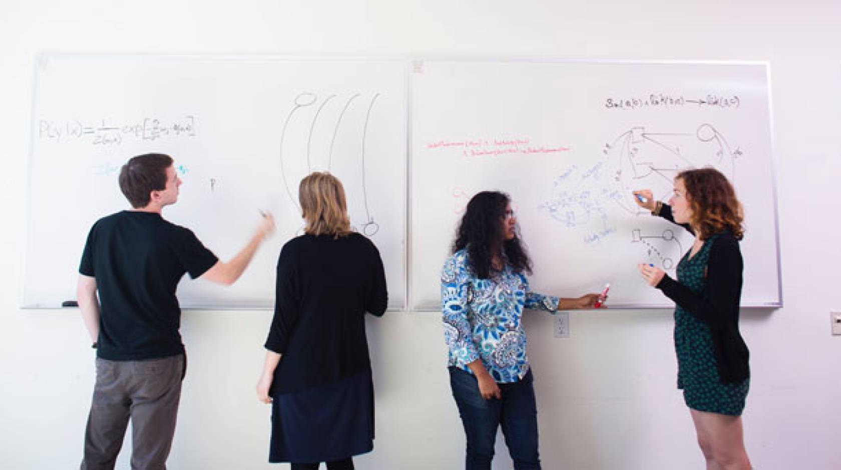 Four students at whiteboards