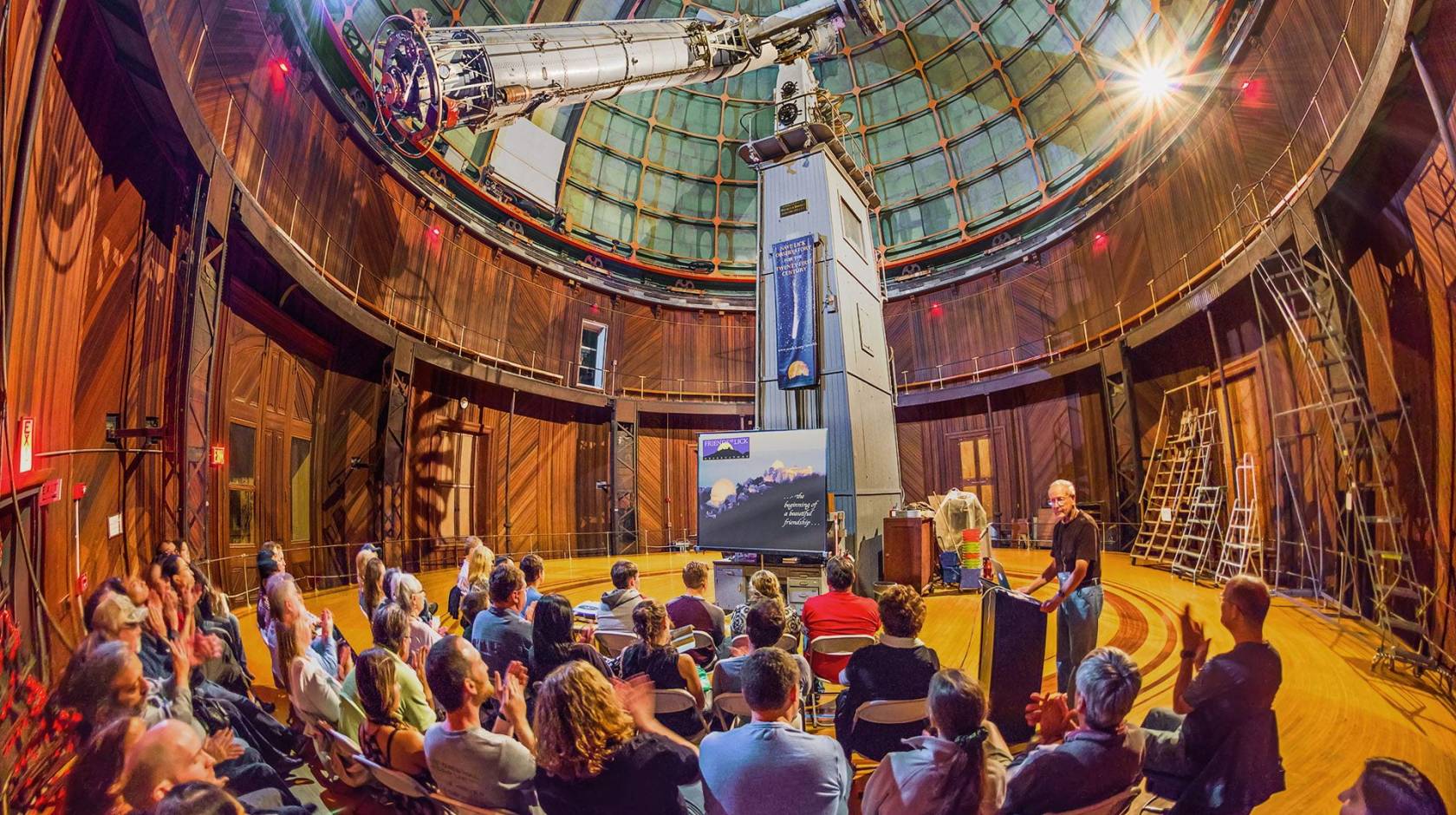 A presentation inside Lick Observatory, telescope visible, taken from a fish-angle lens