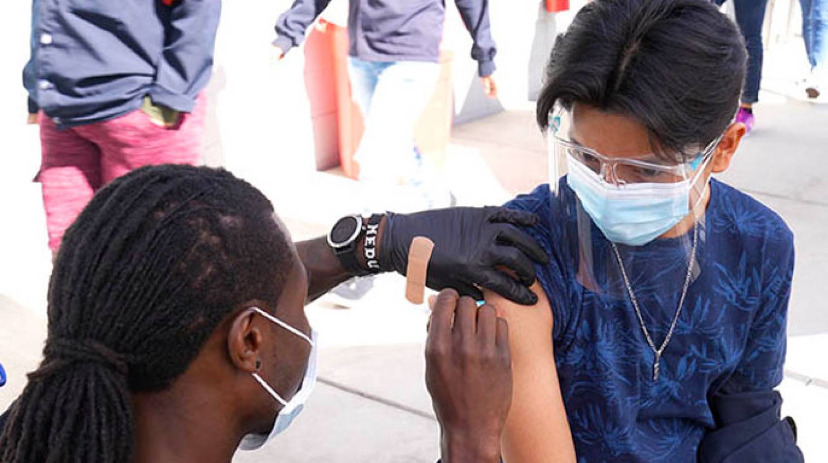 A worker receives a shot from a nurse