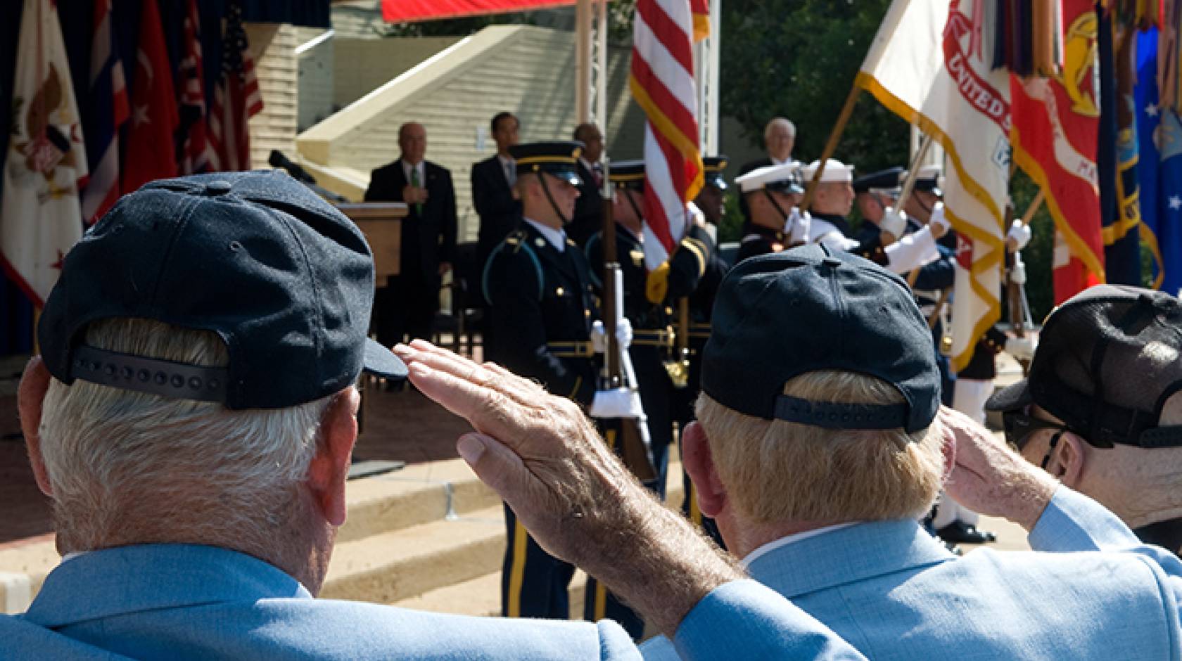Korean War veterans saluting the American flag.