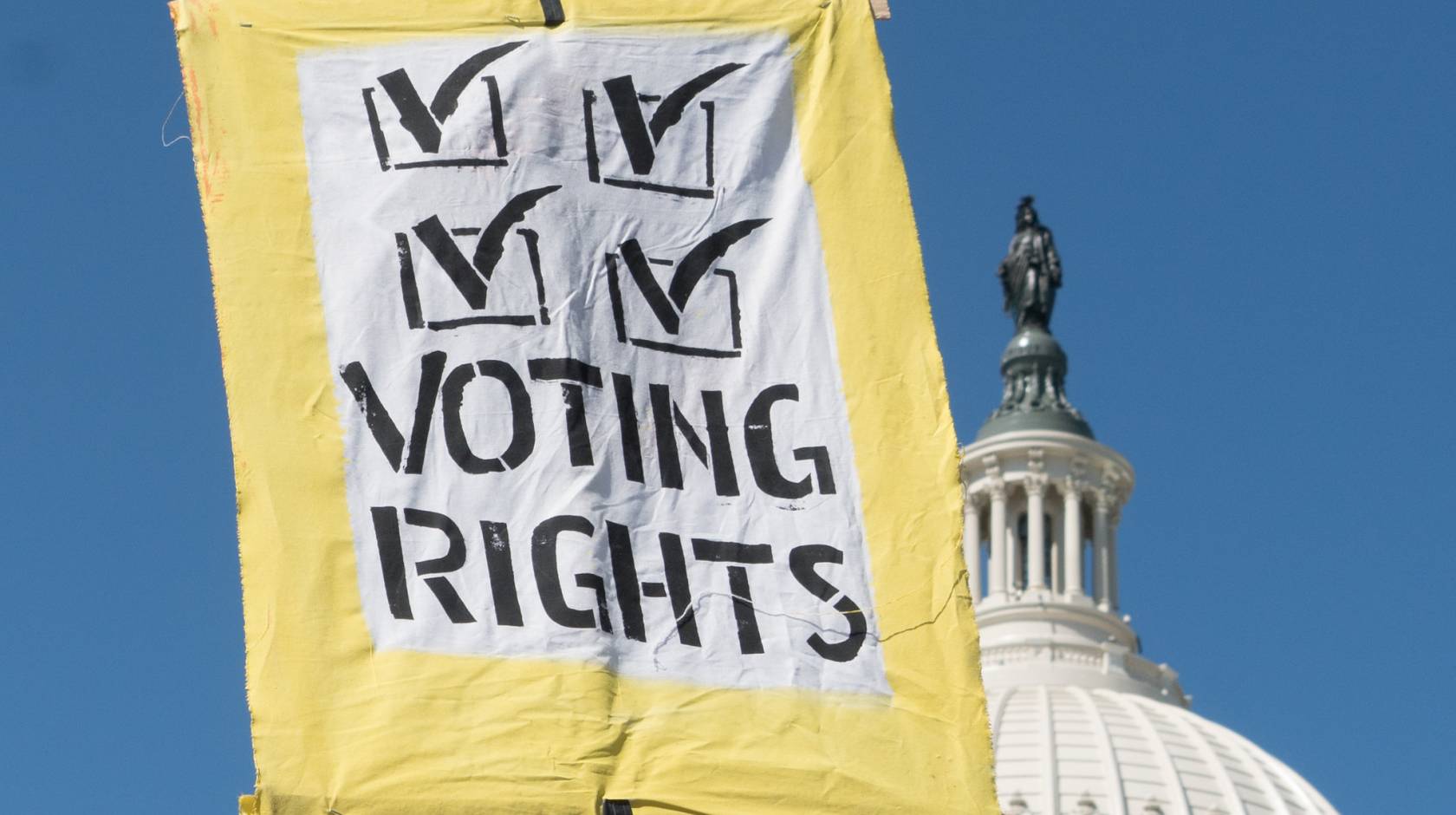 A voting rights sign held up in front of the U.S. Capitol