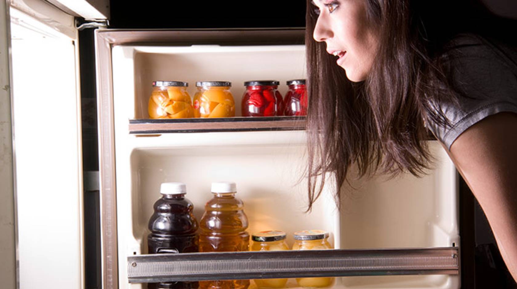 woman looking into refrigerator