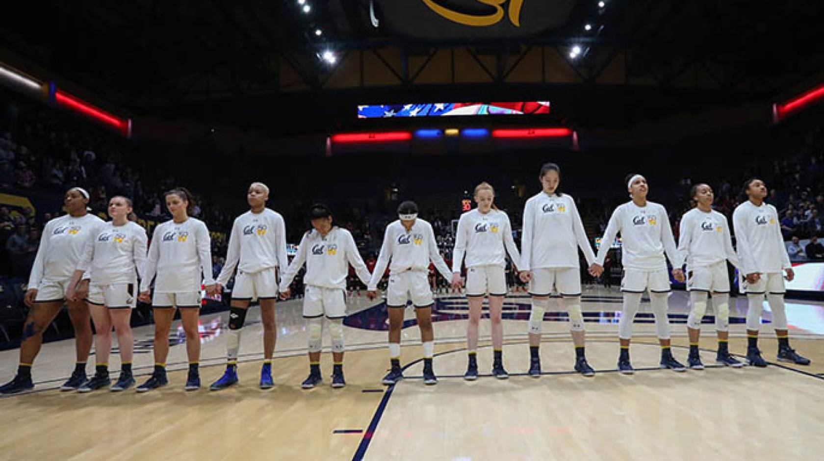 Women standing for anthem at basketball game