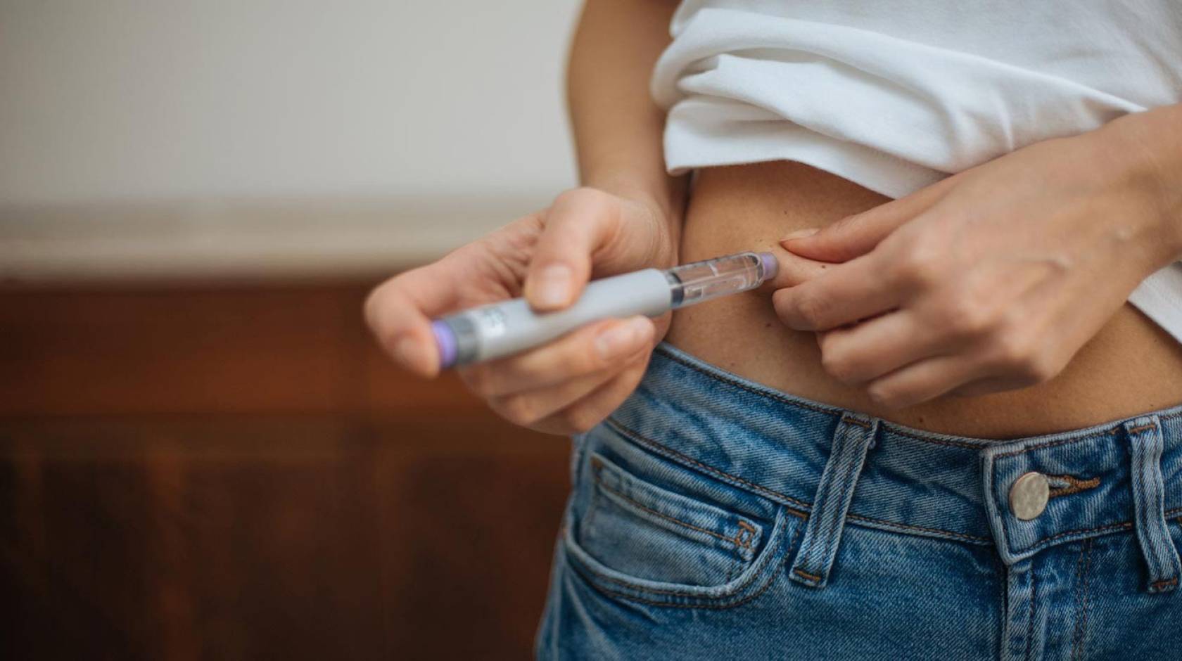 A white woman injecting her midsection