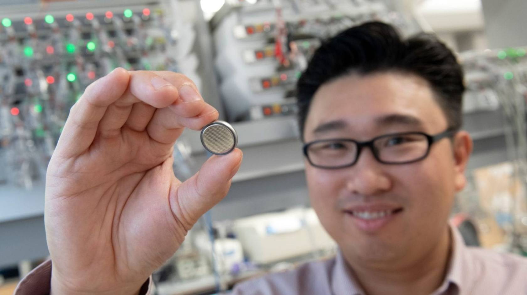 Huolin Xin, UC Irvine professor of physics & astronomy, holds up a small battery