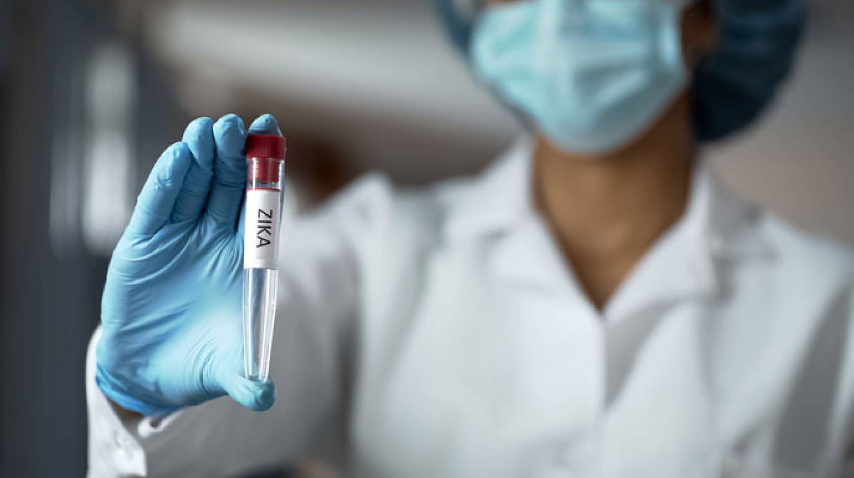 Woman holding a vial of blood in a lab
