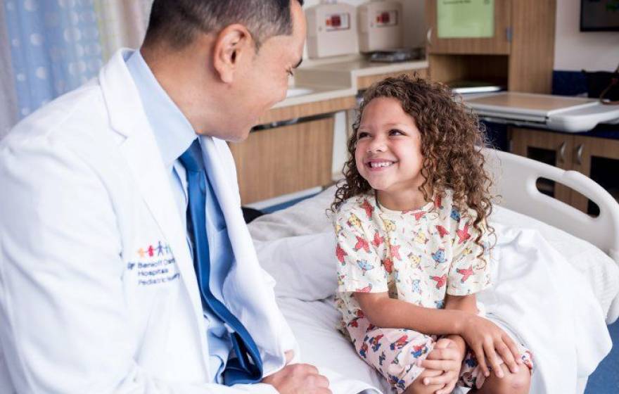 Kurtis Auguste, MD, a pediatric neurosurgeon, talks with a child in the Pediatric Brain Center at the UCSF Benioff Children’s Hospital.