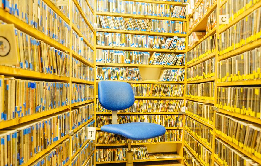 Library stacks and a blue chair