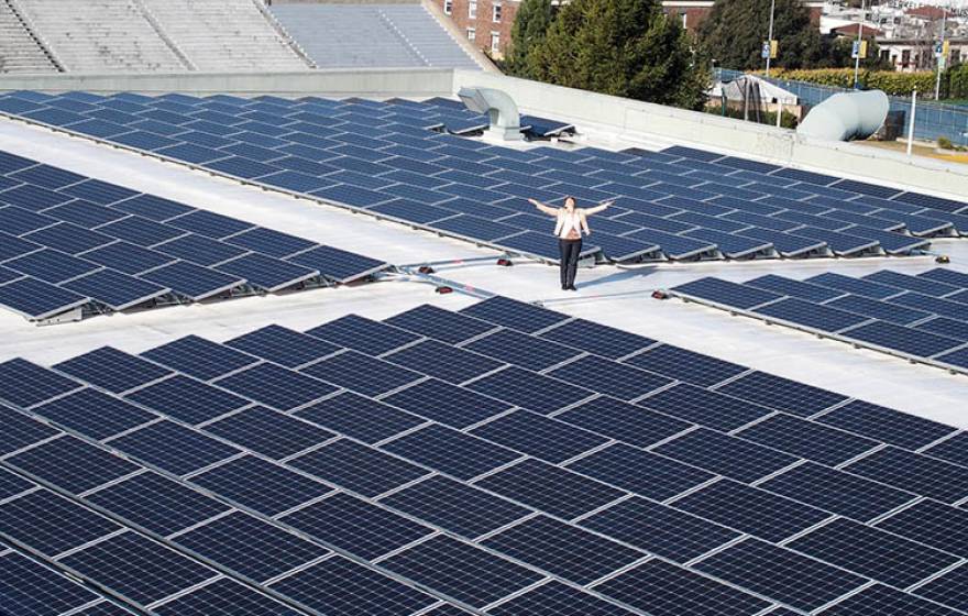 Kira Stoll, UC Berkeley's director of sustainability stands with solar panels on the top of the Recreational Sports Facility. 