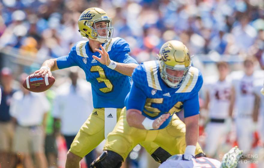 A quarterback in UCLA colors, blue and gold, angles his arm for a pass, while a center, the Niners' Jake Brendel, protects him