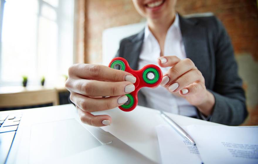 Woman in office playing with fidget spinner