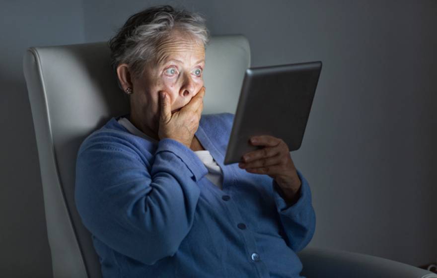 Shocked older woman watching TV on an iPad