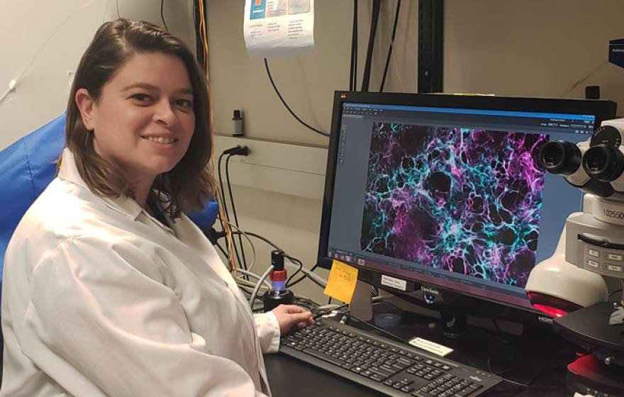 Ariel Krauss sitting in front of a computer with an image of a heart