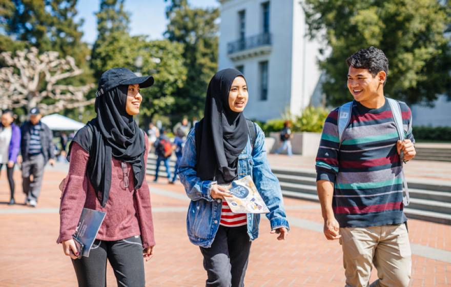 A boy walks next to two fellow students in hijabs on the Berkeley campus