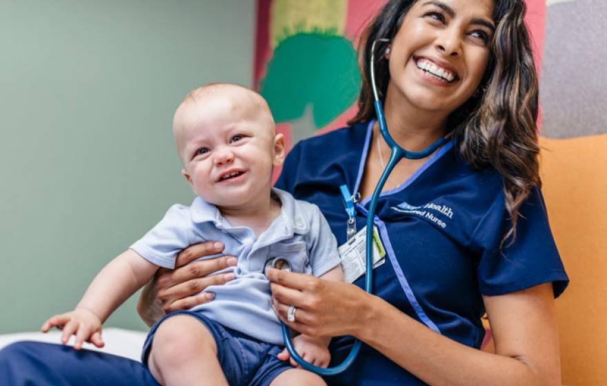 Nurse smiling with a baby