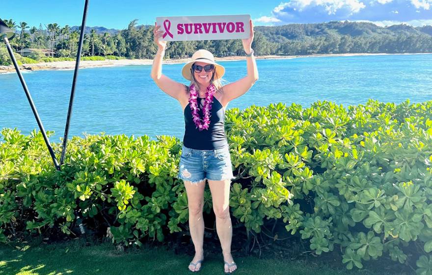 Michelle Brubaker holding up a survivor sign in Hawaii