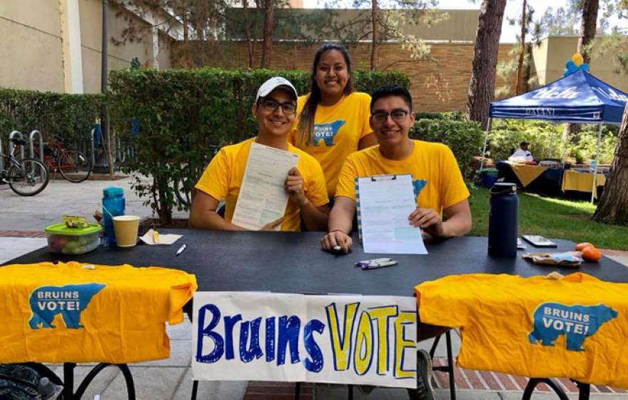 Three UCLA students registering voters at a table