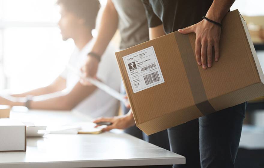 Man's hand on cardboard box 