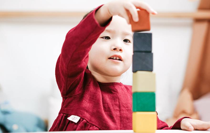 Young child playing with blocks in a classroom