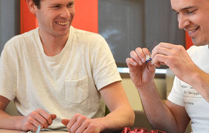 young men examine small tech device