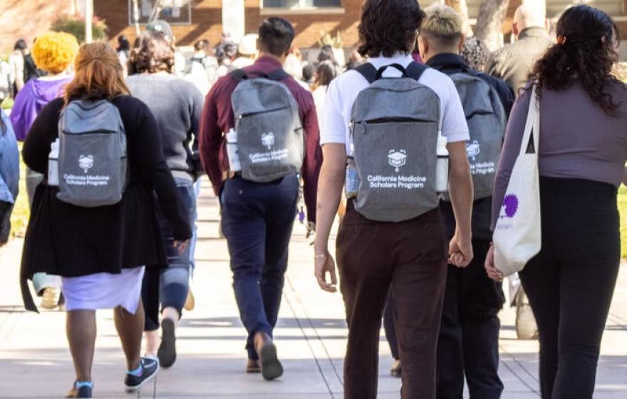 Students walking on UC Riverside campus with California Medicine Scholars Program backpacks