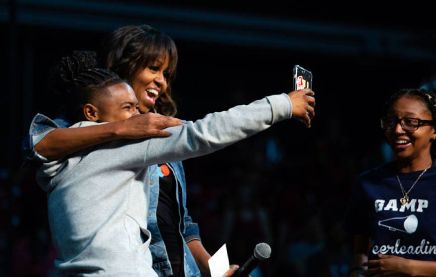 Michelle Obama takes a selfie with a student on College Signing Day