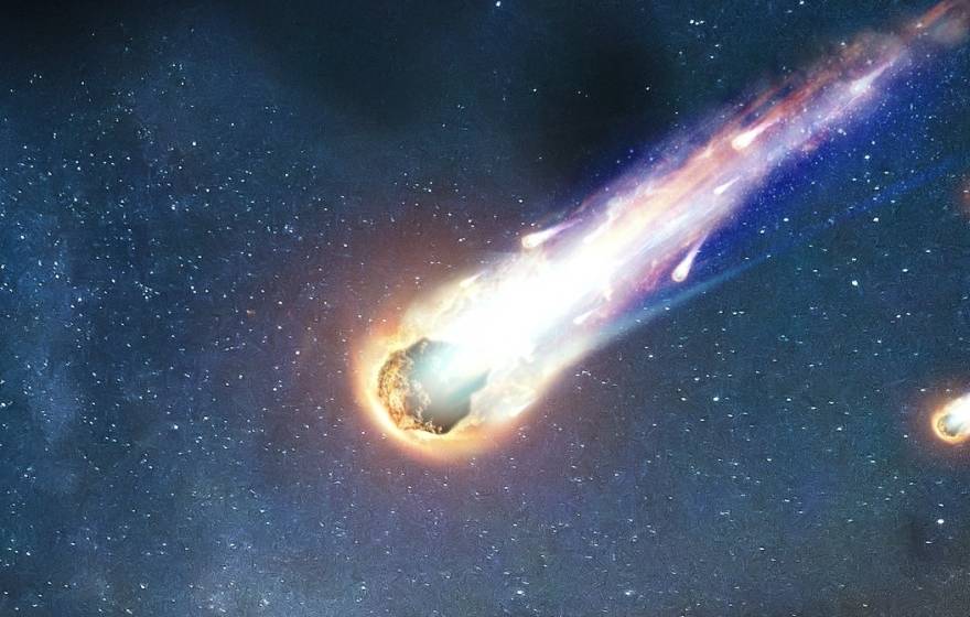 Realistic illustration of a comet with a colorful tail streaking through space, tailed by 2 smaller asteroids