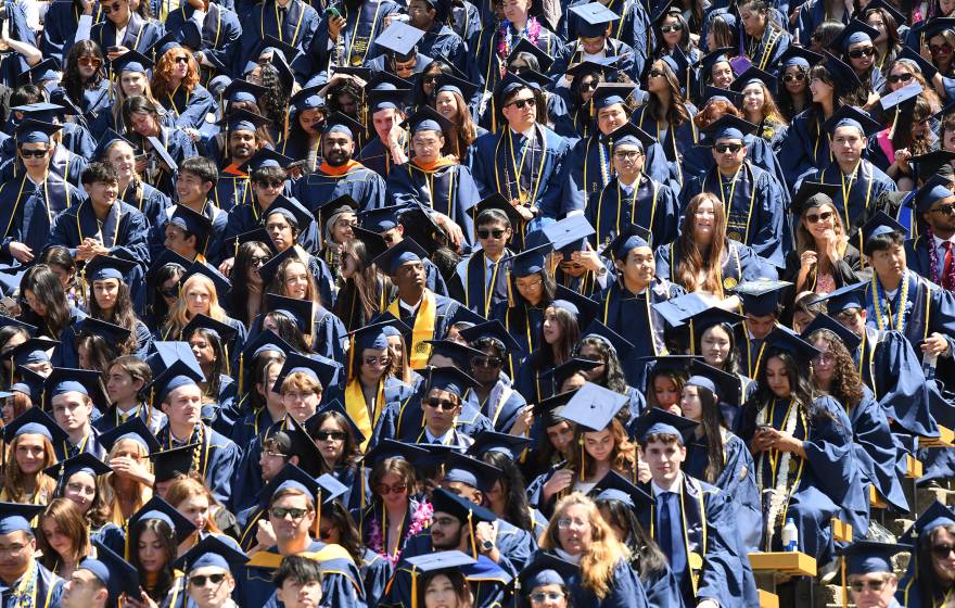 A sea of college students in caps and gowns at graduation