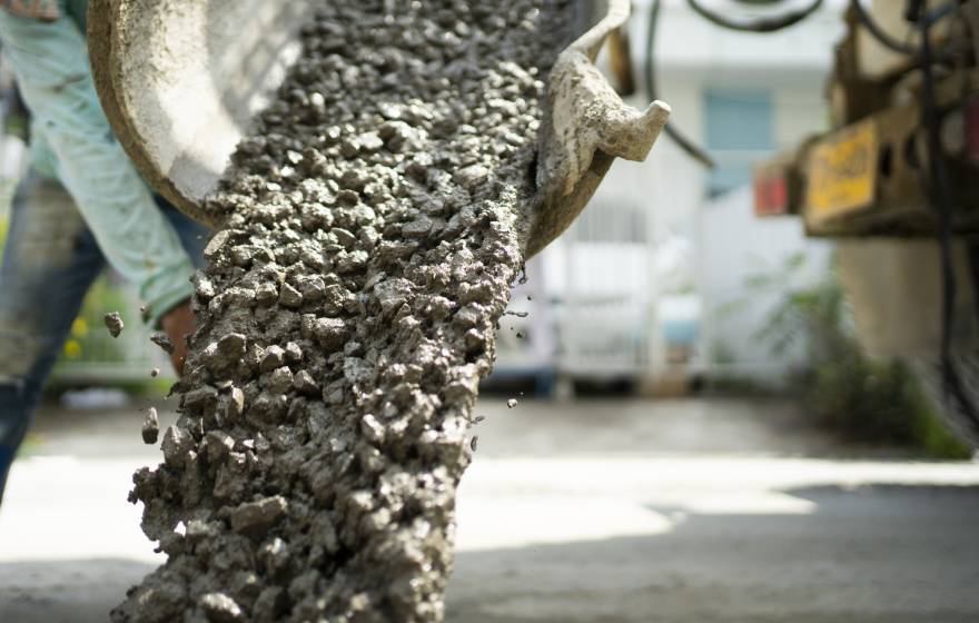 Cement being poured with a worker blurry in the background