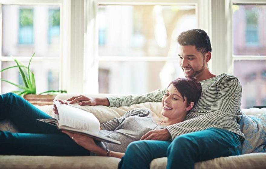 smiling couple sitting on couch