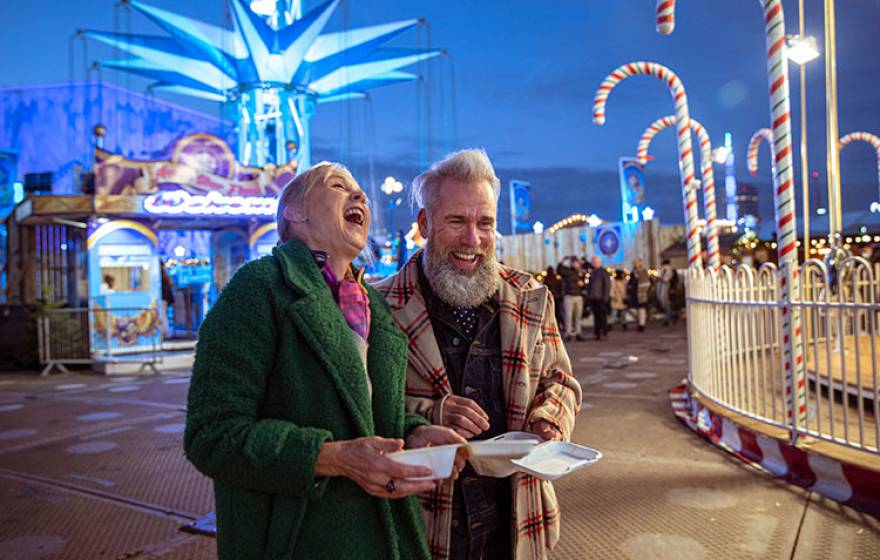 An older couple laughing at a carnival