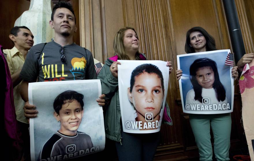DACA recipients hold pictures of themselves as children during a Congressional meeting