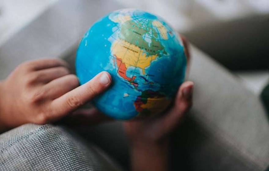 Finger pointing at globe